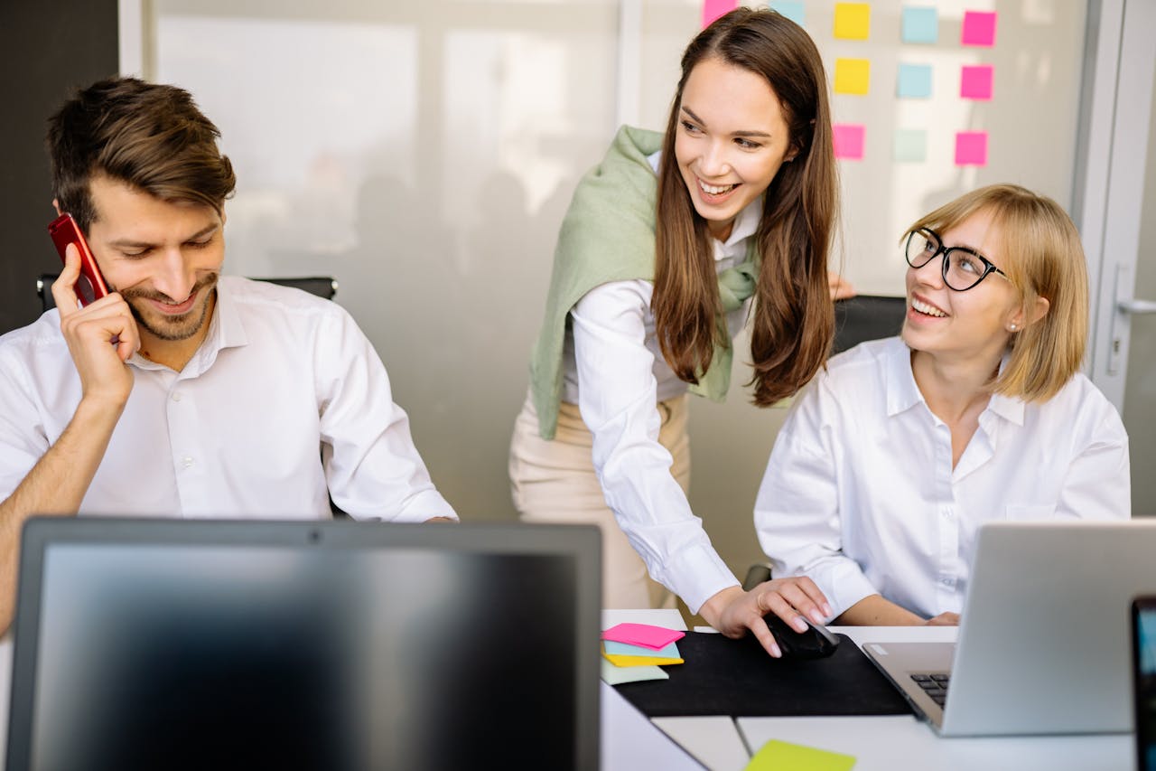 about-us Business professionals collaborating at a meeting with laptops and notes in a modern office setting.