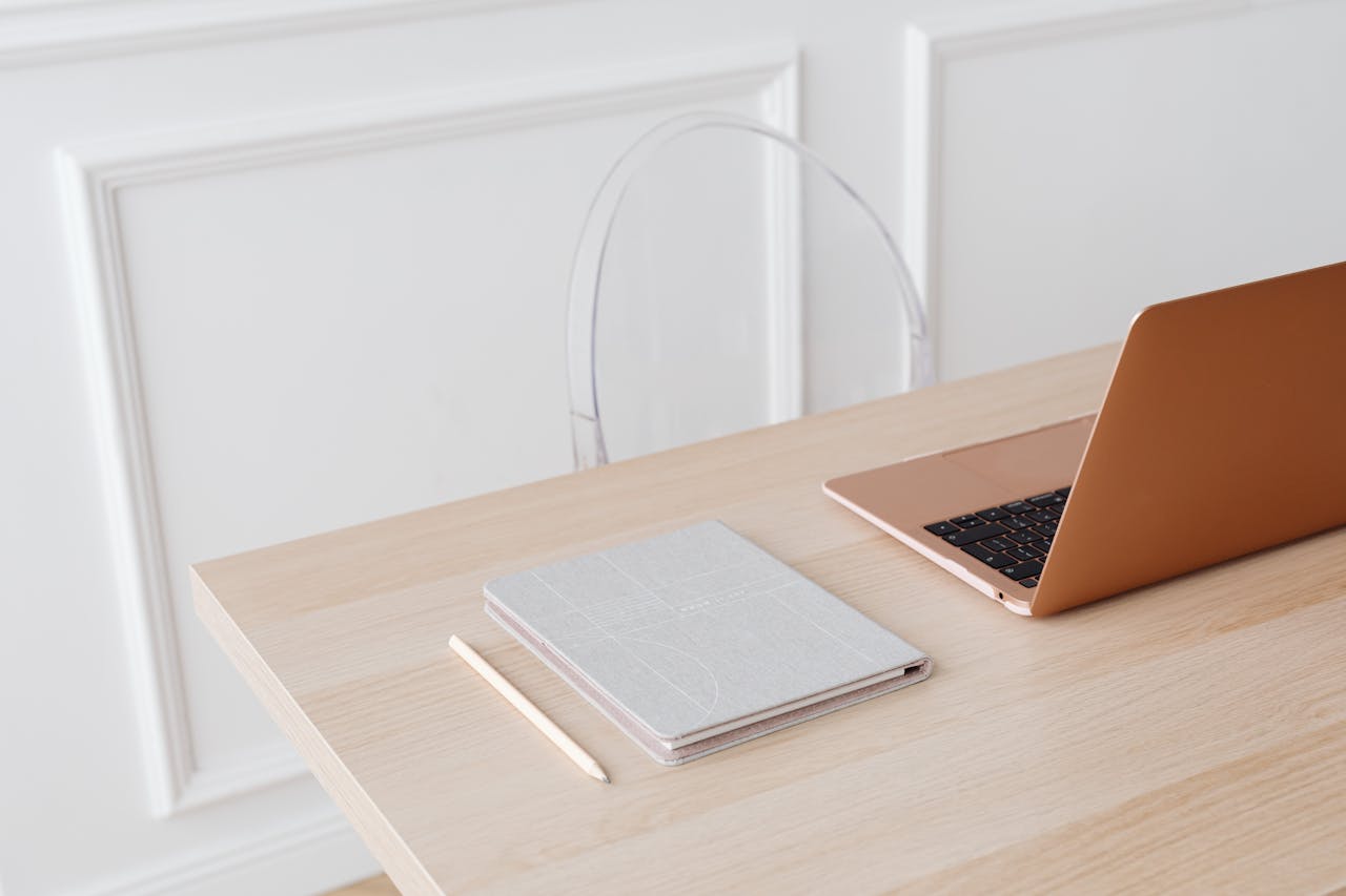 Mastering the First Impression: Your intriguing post title goes here Bright, minimalist setup featuring a laptop and notebook on a wooden desk, perfect for modern workspace inspiration.